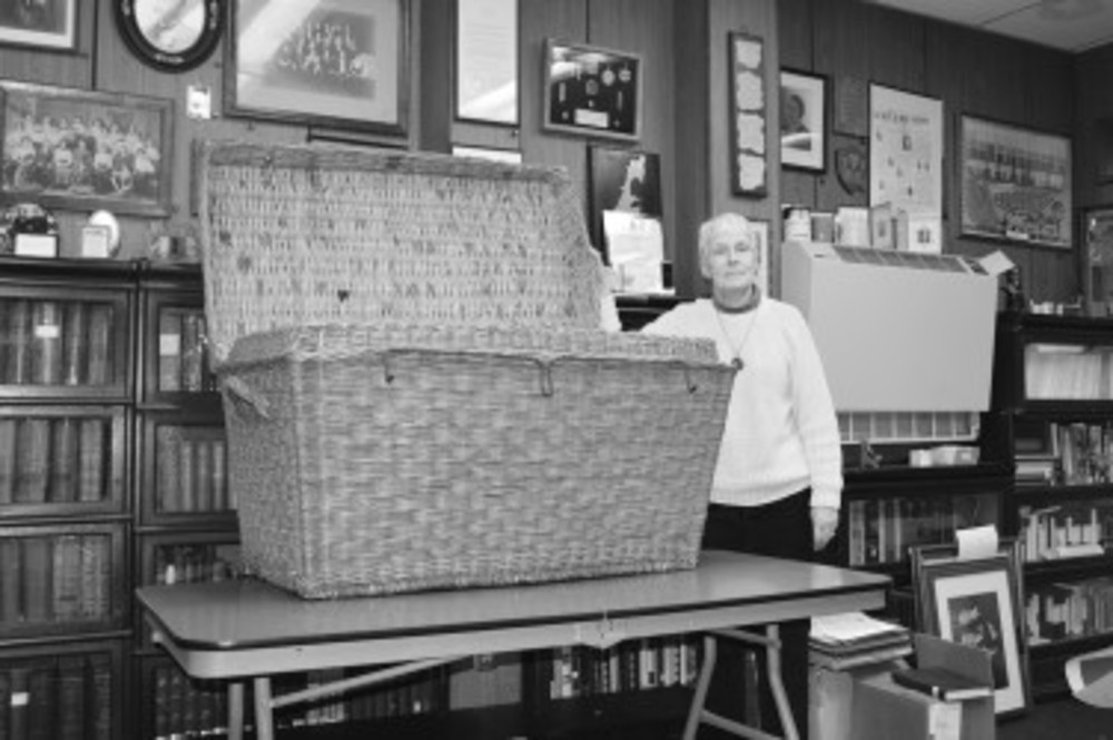 Anne Sherman shows off the Bojar’s wicker trunk in the RIJHRI office /The Jewish Voice Staff